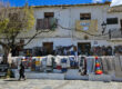 Plaza central de Pampaneira, Alpujarra de Granada: vista pintoresca de la plaza principal con una tienda tradicional de jarapas, donde se exhiben coloridos textiles artesanales. Un reflejo del encanto rústico y la autenticidad de este pintoresco pueblo blanco andaluz.
